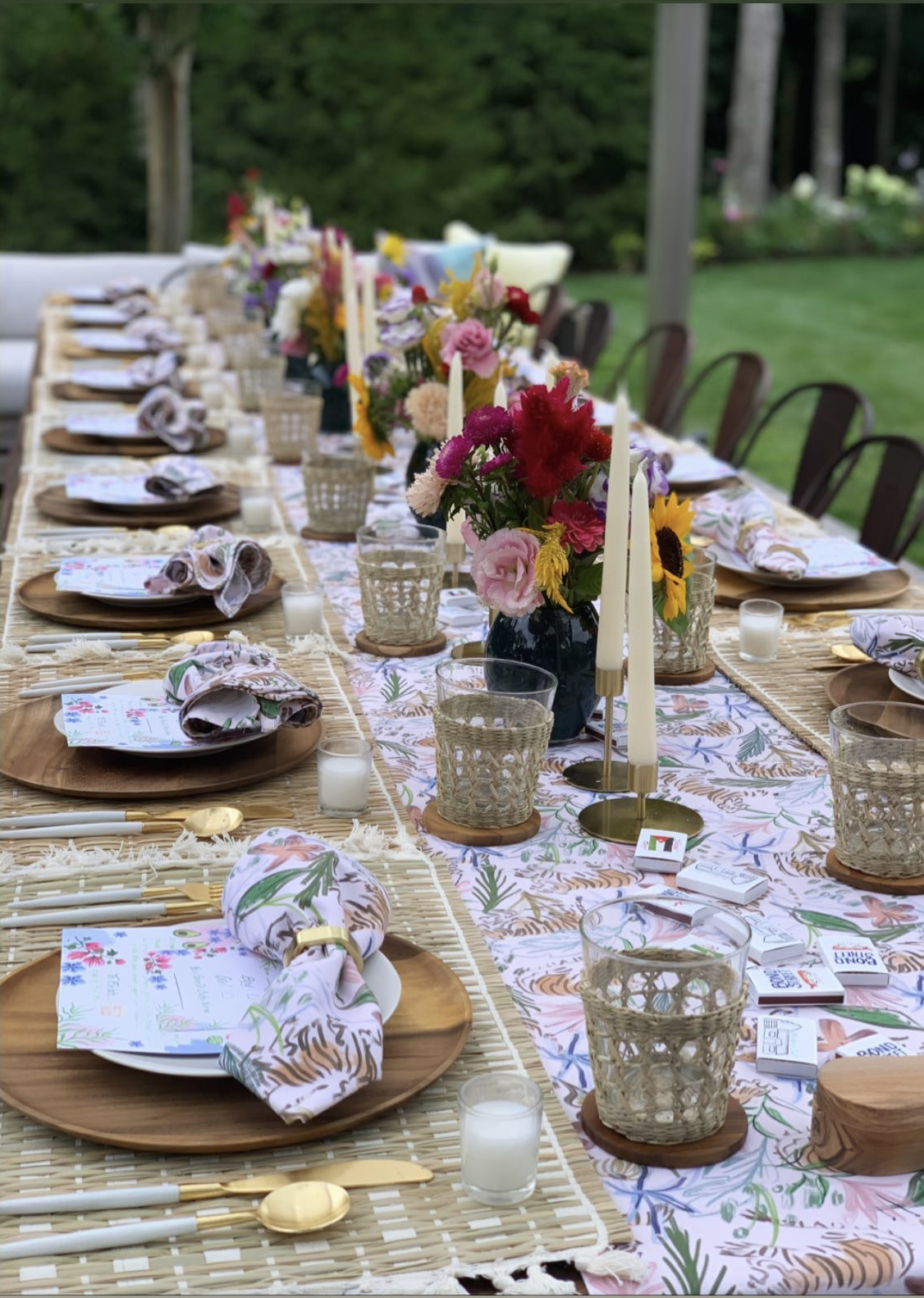 Table setting for an event styled with a Pink Chinoiserie Tiger custom table runner  and napkins with flowers in black vases in the center