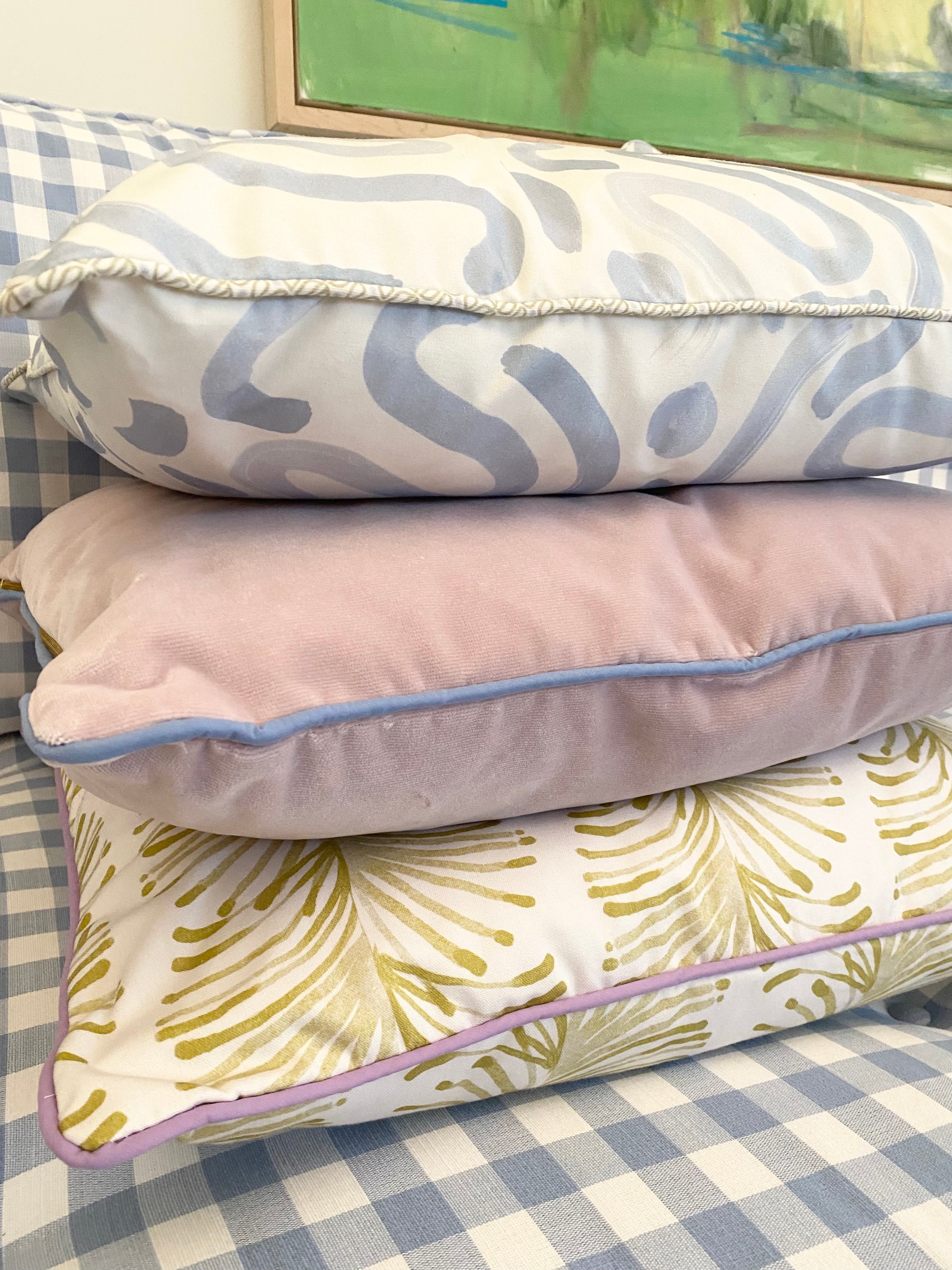 Close-up of a Yellow Stripe Chartreuse custom pillow, a pink velvet custom pillow, and an Abstract Sky Blue custom pillow