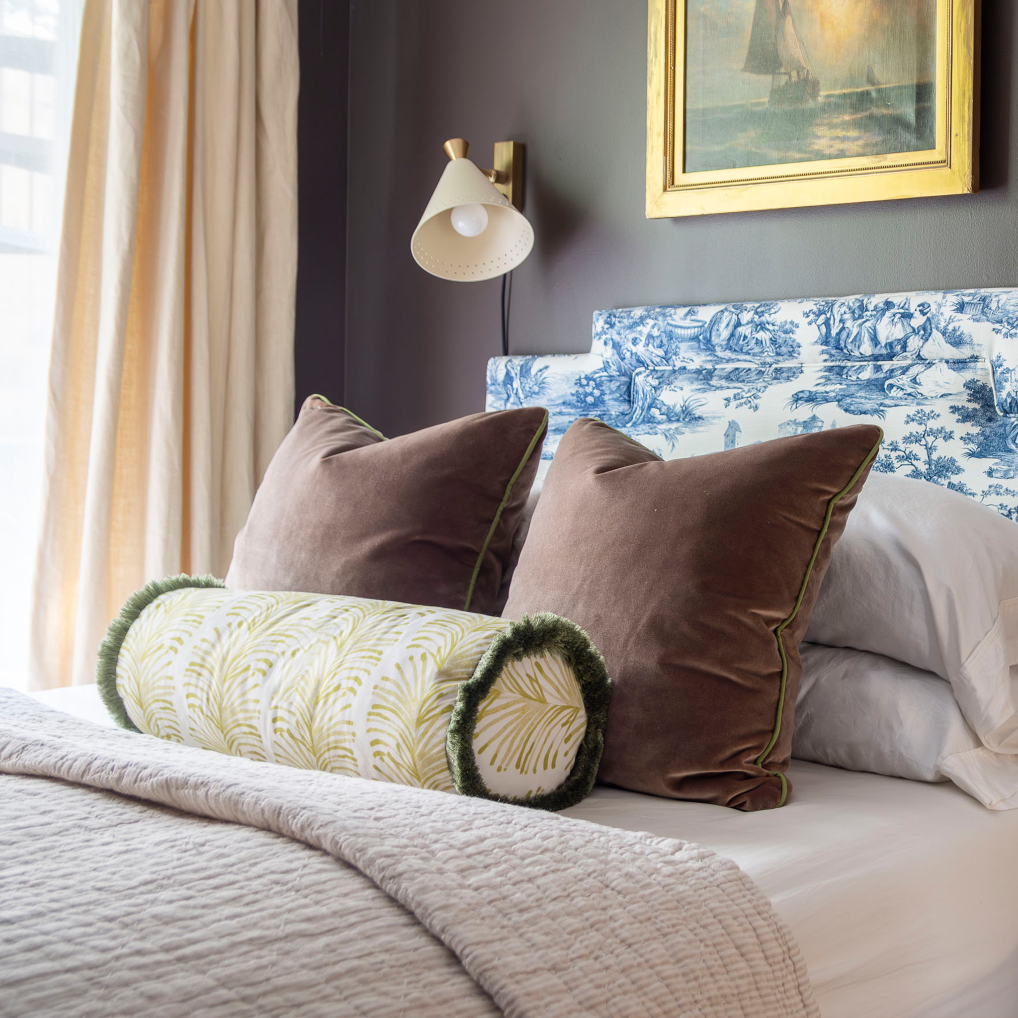 Bed close-up styled with two brown velvet custom pillows and one Yellow Stripe Chartreuse custom bolster pillow