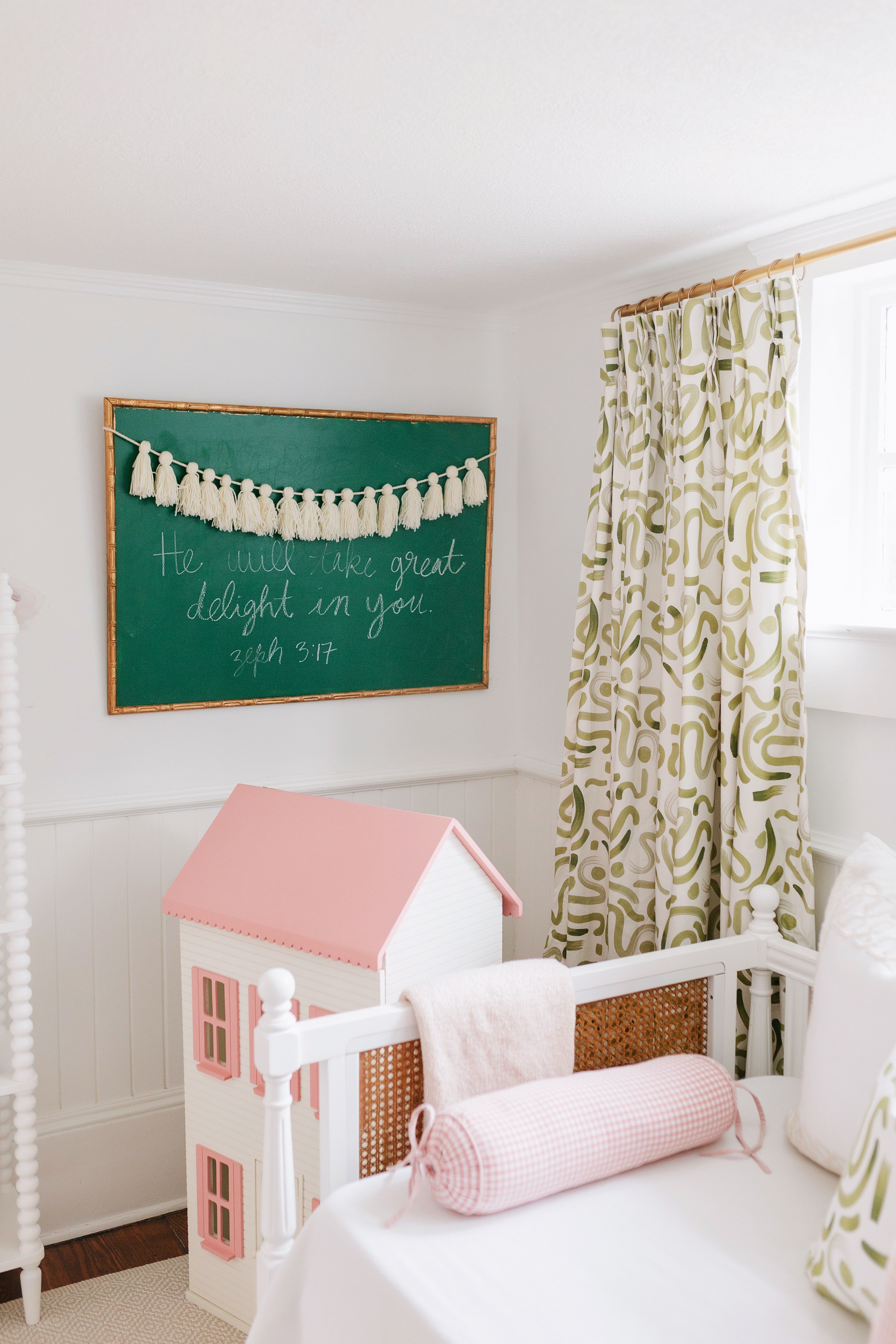 Moss abstract curtain panel hanging on a window behind a white daybed next to a green chalkboard