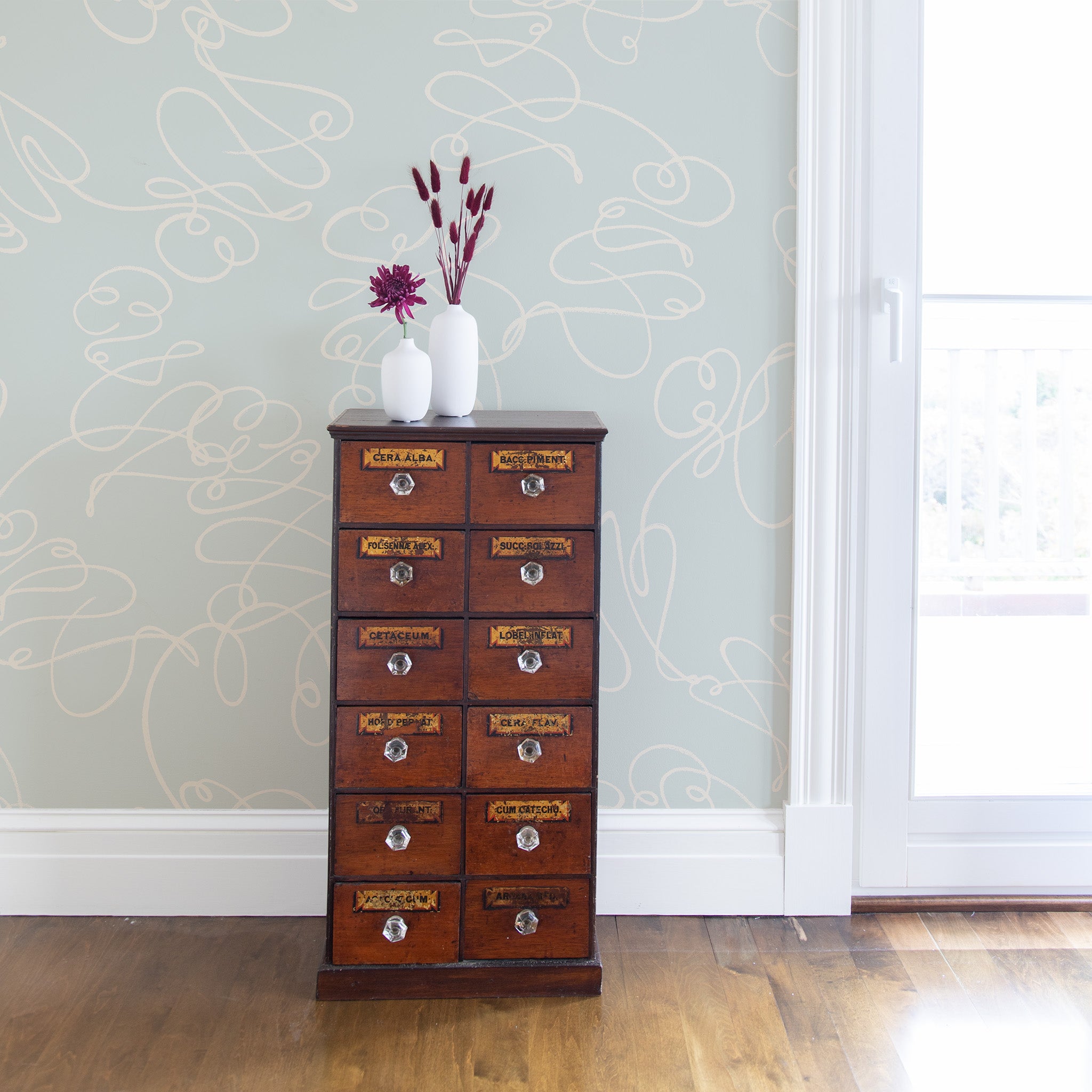 Powder Blue Abstract wallpaper styled with a small brown chest next to a glass door