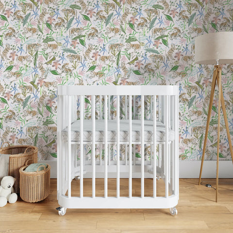 Nursery room with white crib in between two baskets and a tall lamp in front of Pink Chinoiserie Tiger Custom Wallpaper