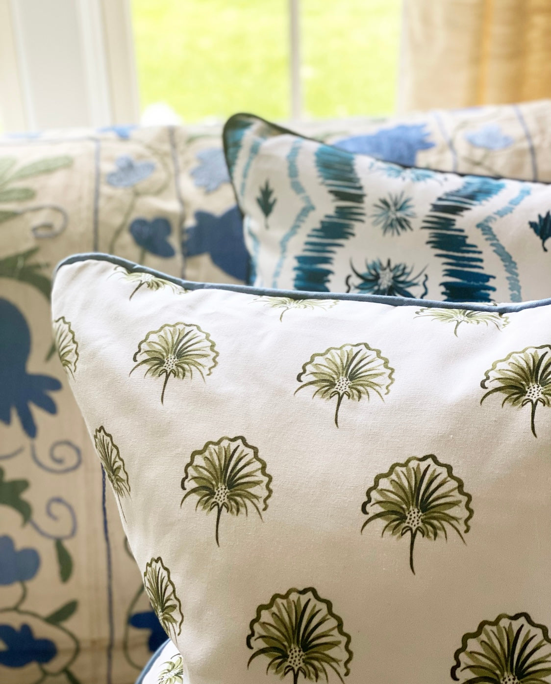 Close-up of Green Floral custom pillow and Blue Ikat custom pillow