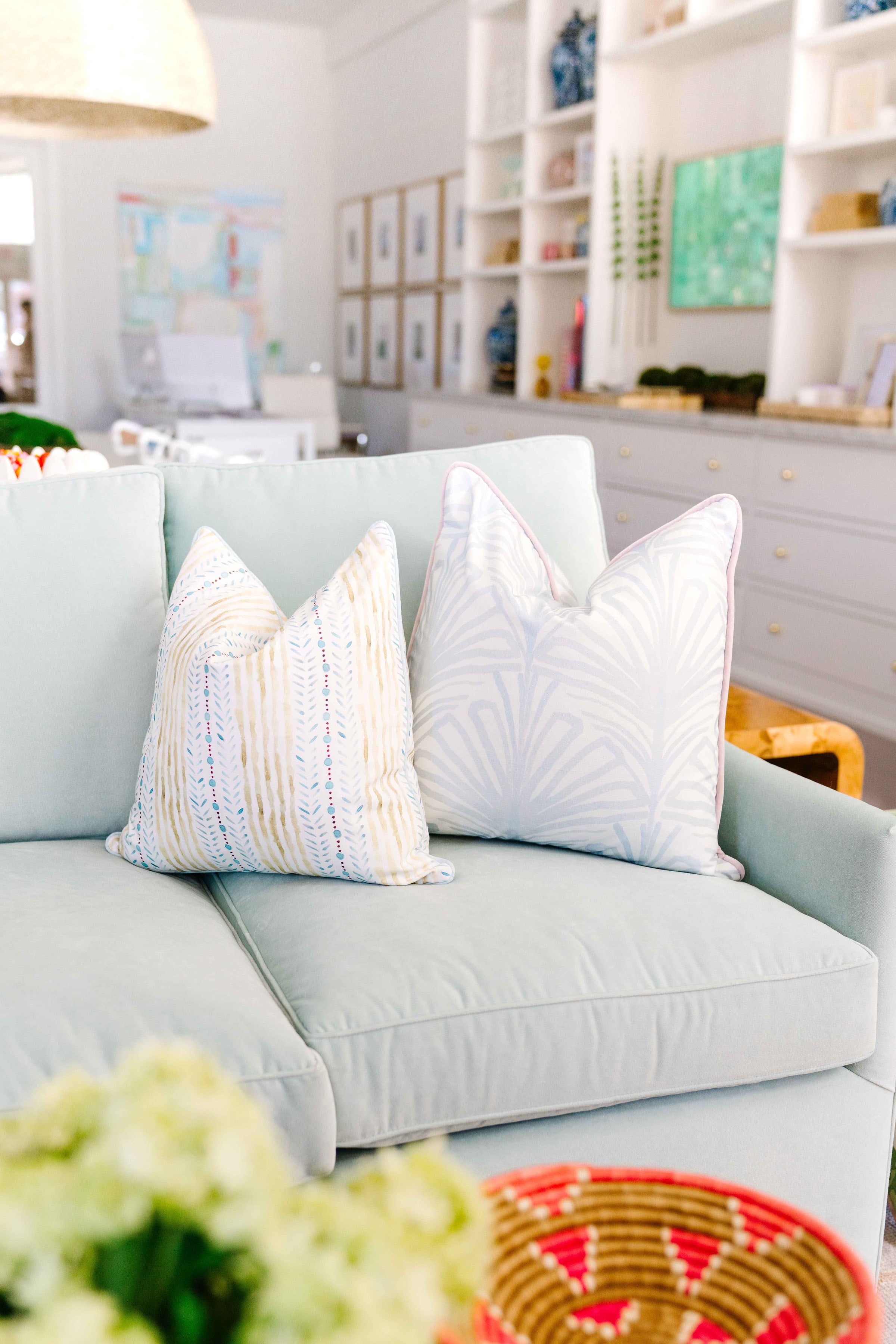 Close-up of Blue & Green Striped Custom pillow and Sky Blue Botanical Stripe Custom Pillow on blue green velvet couch