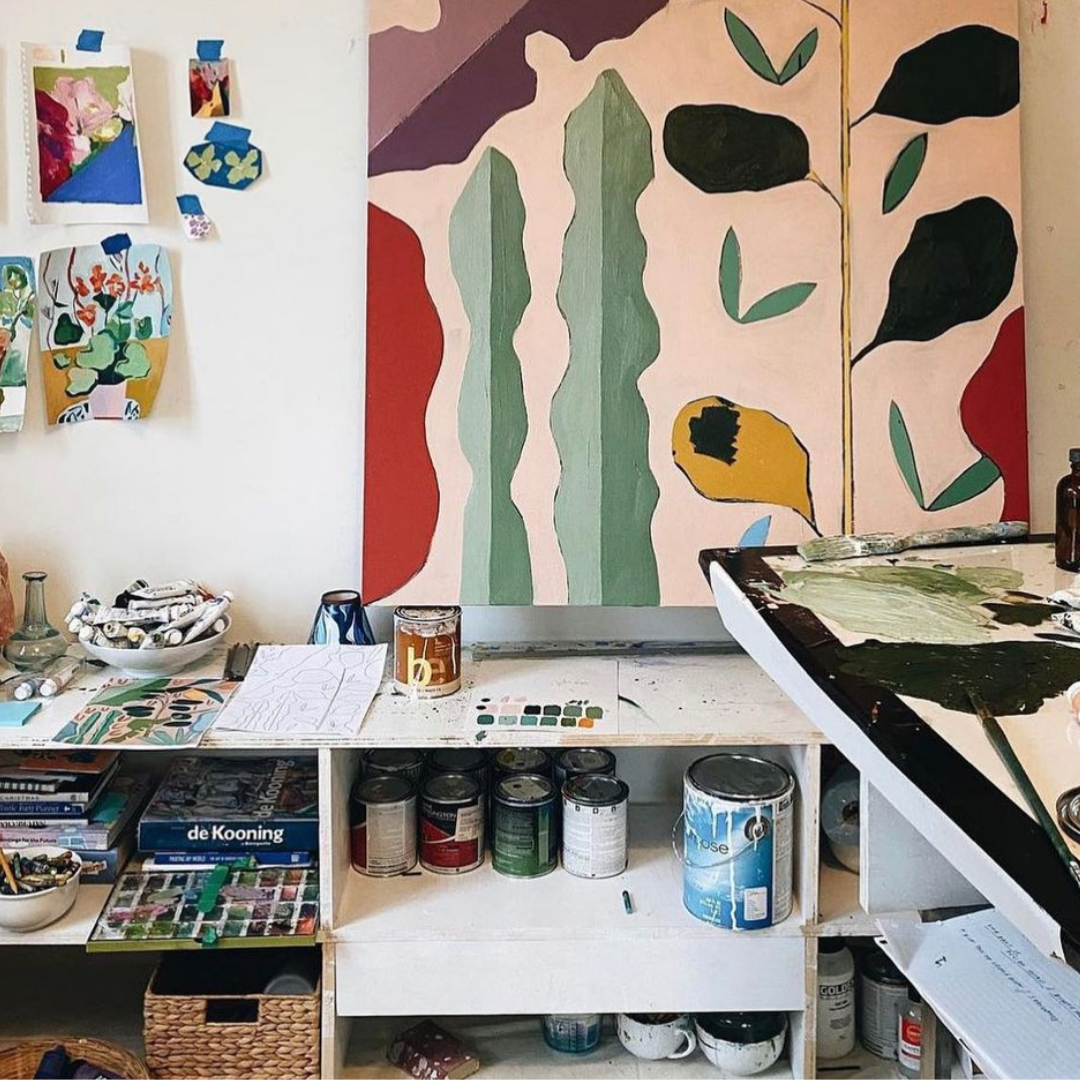 Art studio with big artwork in the middle and paint in the bottom shelves