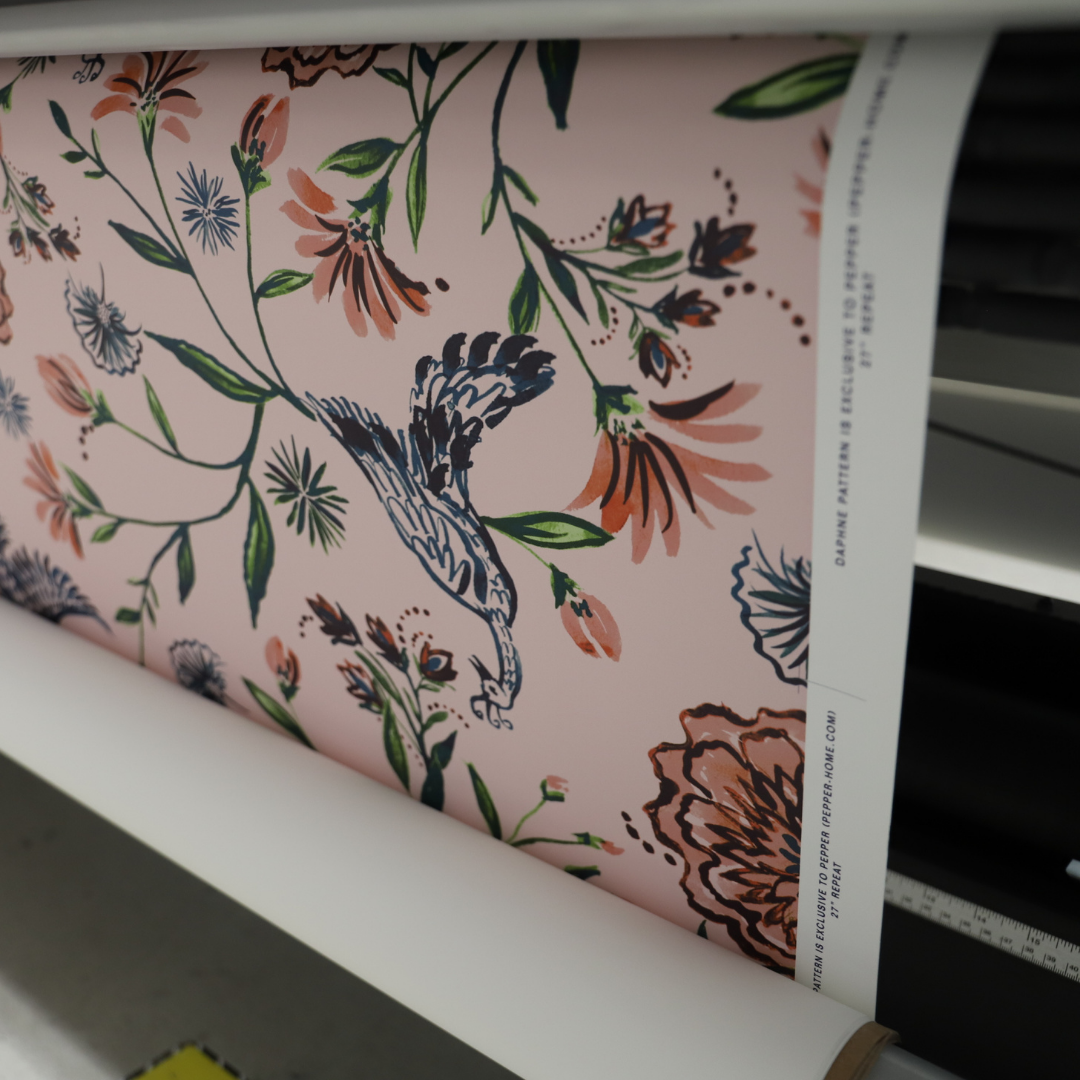 Rose chinoiserie wallpaper roll coming off of a printer
