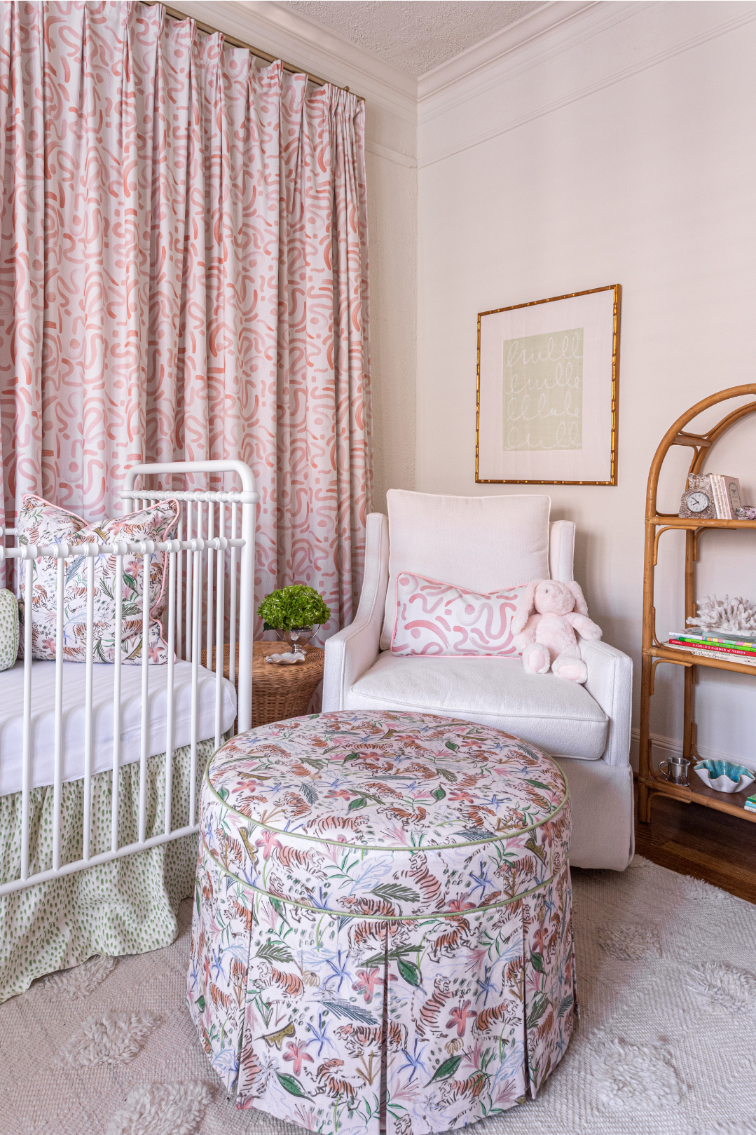 Nursery room corner styled with Pink Graphic Custom Lumbar on Pink Sofa Chair next to white crib with Pink Chinoiserie Custom Pillow next to Pink Chinoiserie Custom Ottoman and Pink Graphic Custom Curtains