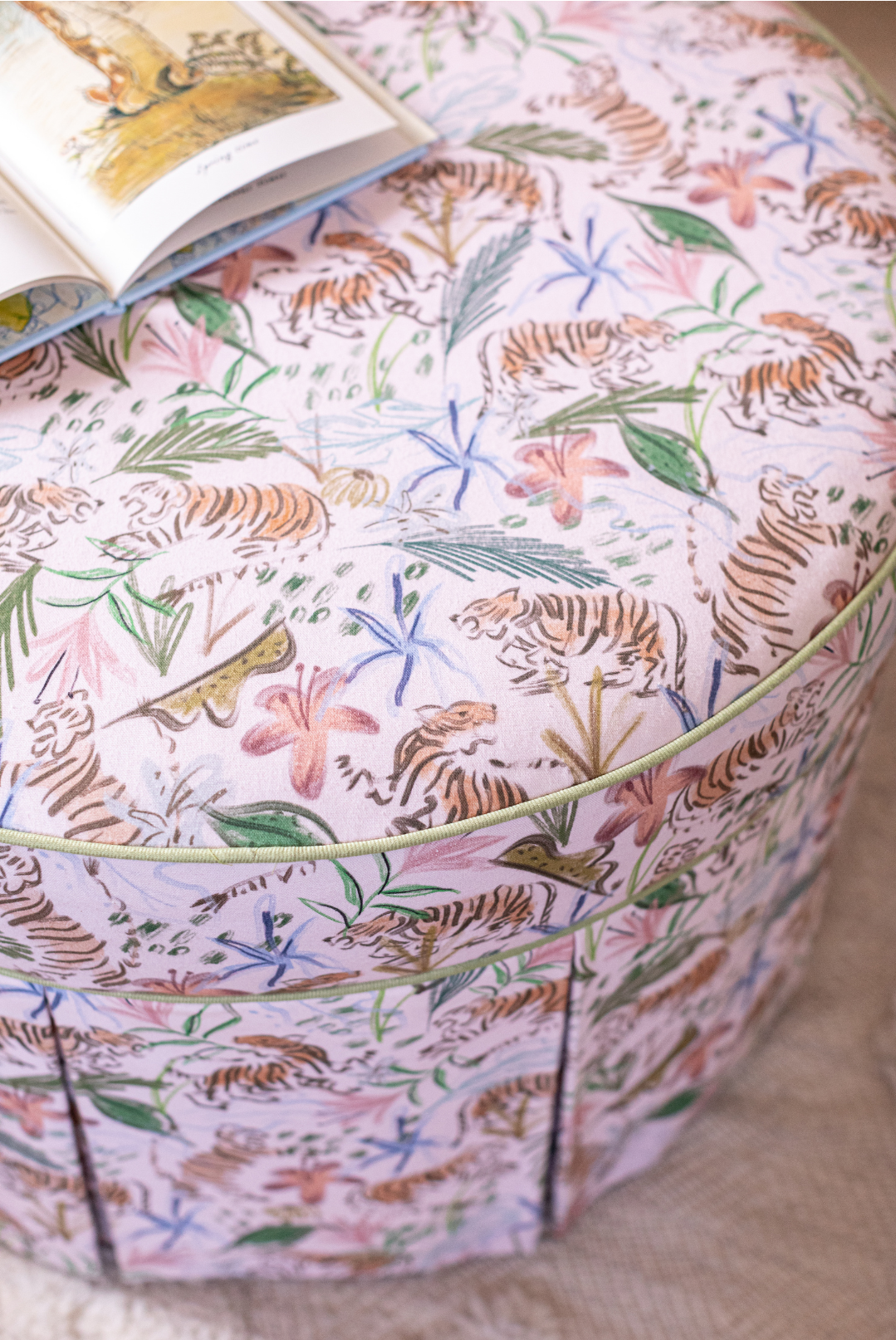 Close-up of Pink Chinoiserie Tiger Custom Ottoman with an opened children’s book