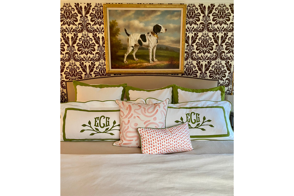 Bed close-up styled with three white and green pillows, two white and green monogrammed lumbar pillows, a Pink Graphic custom pillow, and a red and pink custom lumbar pillow