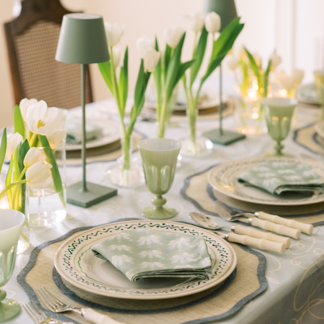 Table setting styled with a Powder Blue Abstract Custom Tablecloth and Coastal Inspired Green and Blue custom napkins with white tulips in the center as decoration