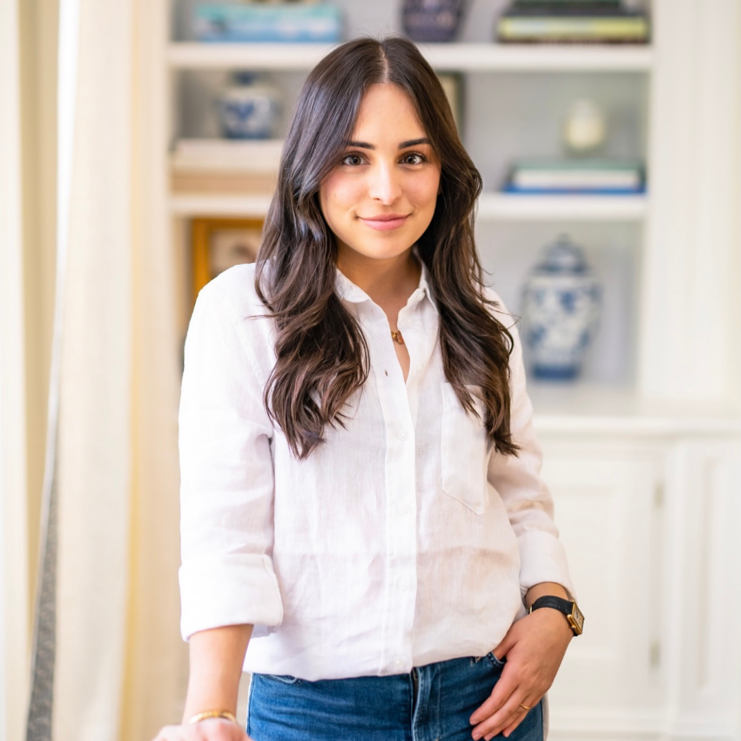 Headshot of brunette woman smiling wearing a white t-shirt and jeans