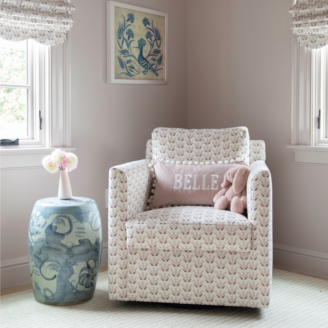 Pink & Burgundy Drop Repeat Floral heavyweight linen glider with a pink velvet pillow styled in a nursery with pink walls and a blue garden stool