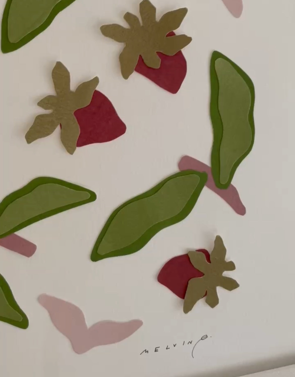 Close up of cut paper collage of red strawberries and pink stems