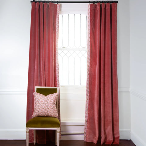 Coral Velvet Custom curtains with a Pink Floral Custom Band on metal rod in front of an illuminated window with a Green Moss Velvet chair with Pink Floral Custom Pillow on top
