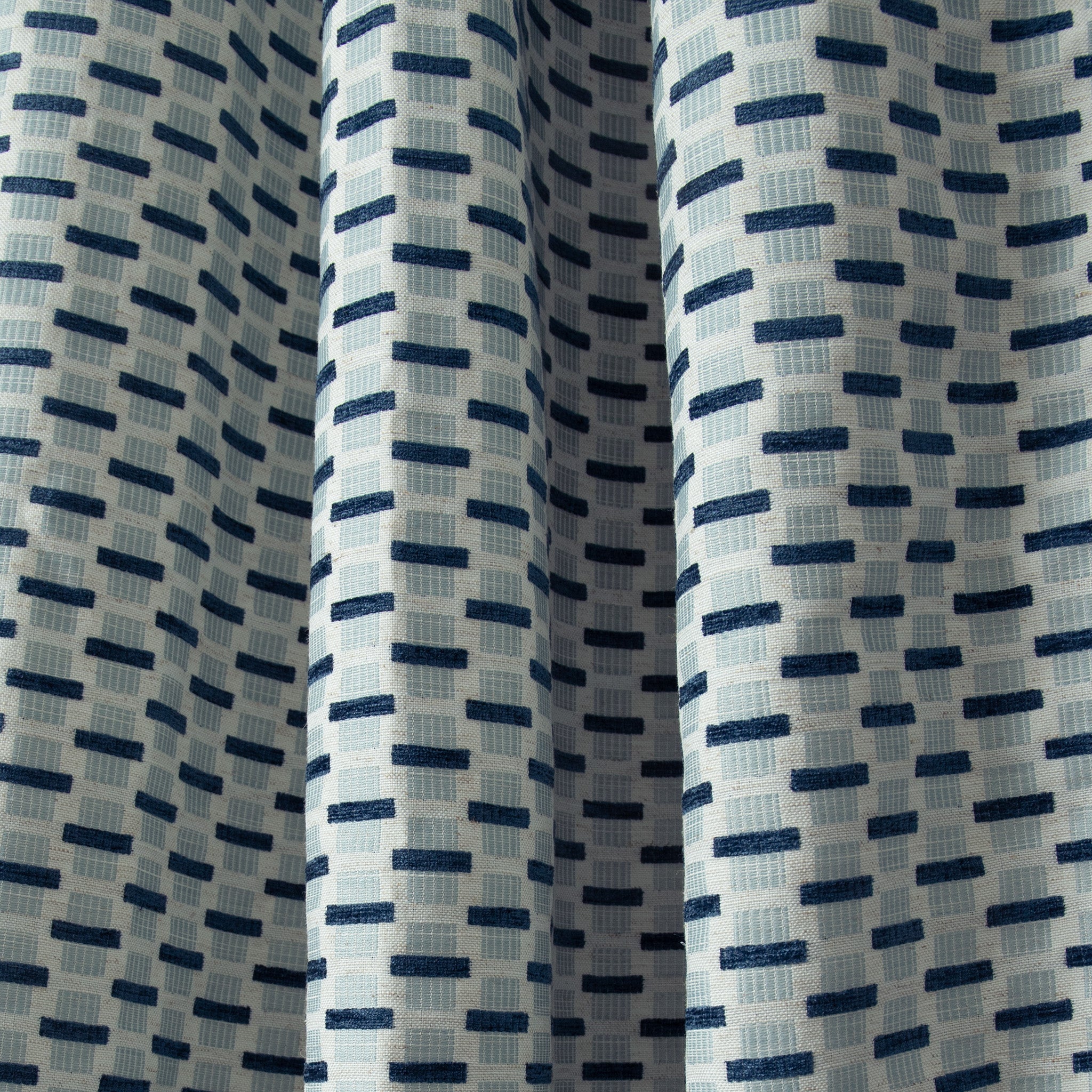 Close up of light blue and navy velvety jacquard and woven chenille