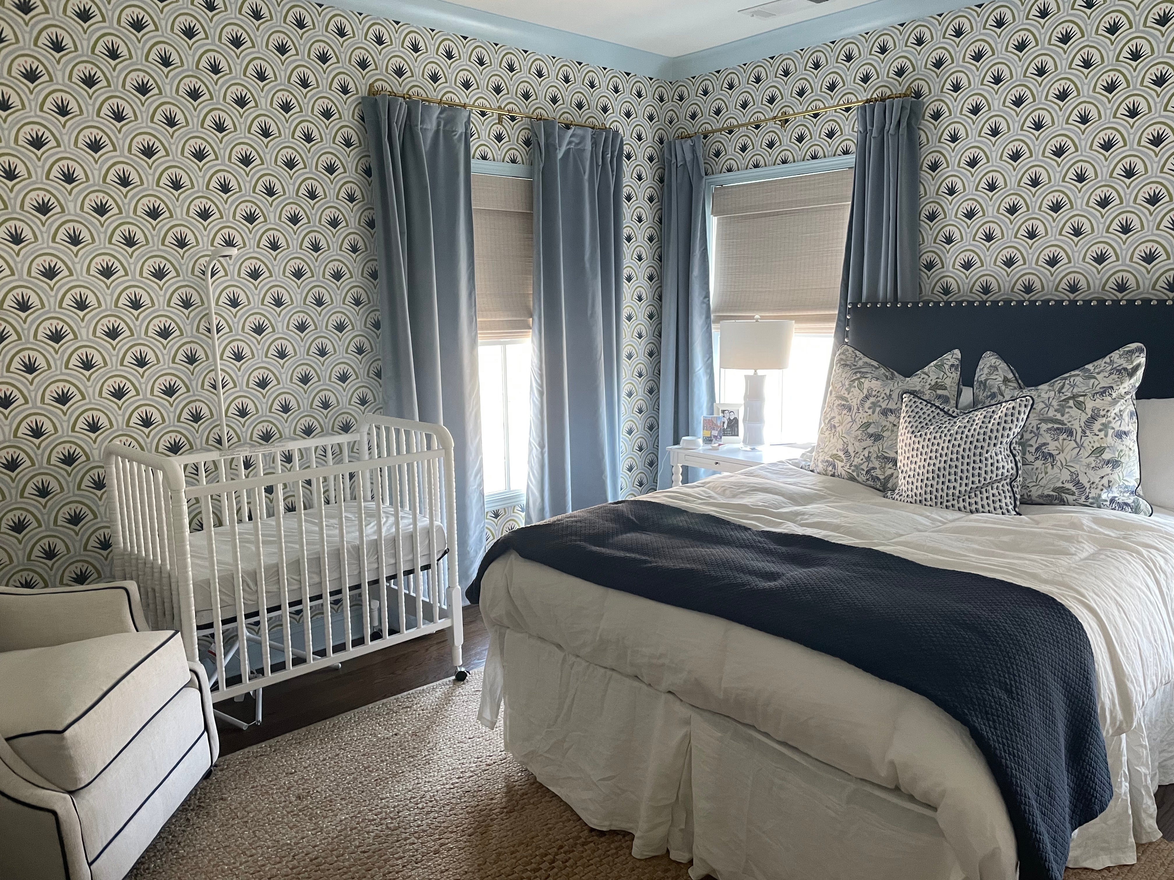 Bedroom with blue and green art deco palm wallpaper styled with sky blue velvet custom curtains and a navy upholstered bed with tiger chinoiserie blue pillows