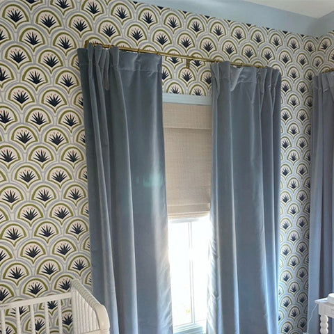 Close-up of an illuminated window styled with Sky Blue Velvet Custom Curtains and Art Deco Palm Pattern Custom Wallpaper