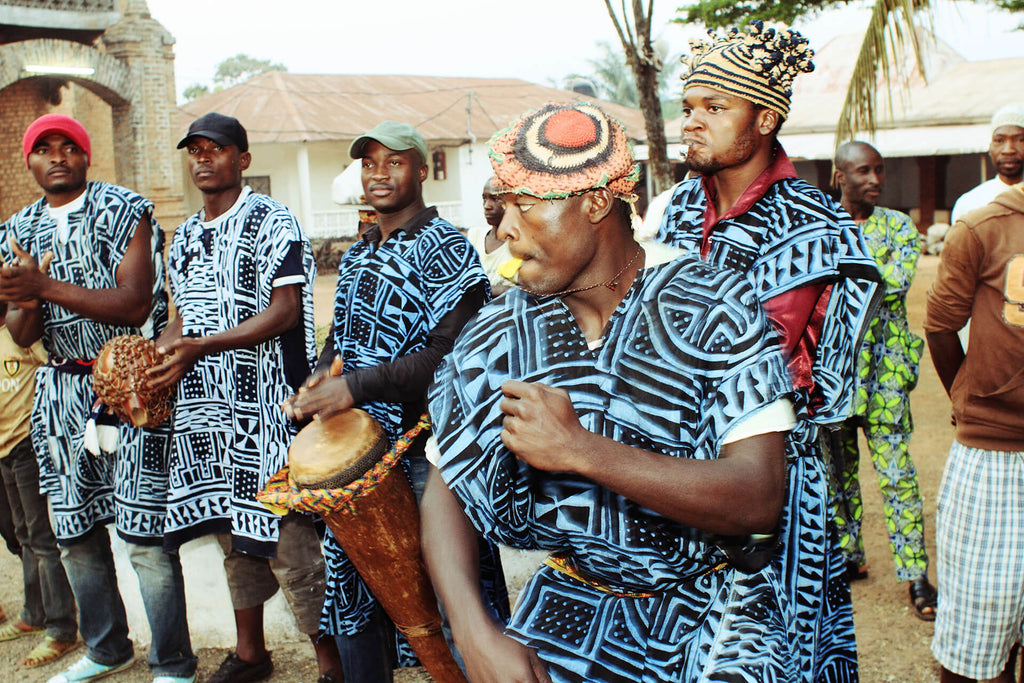 Cameroon band wearing cultural clothing & playing music.