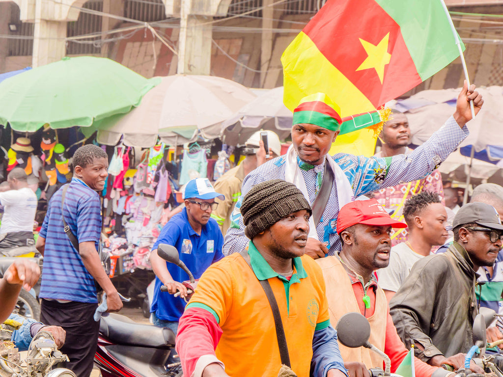 Cameroon market with Cameroonians waving the Cameroon Flag