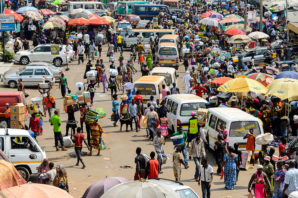 Road with cars and a crowd people at the market