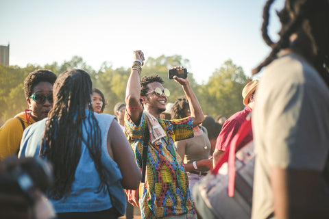 Black person smiles and dances in outdoor festival setting