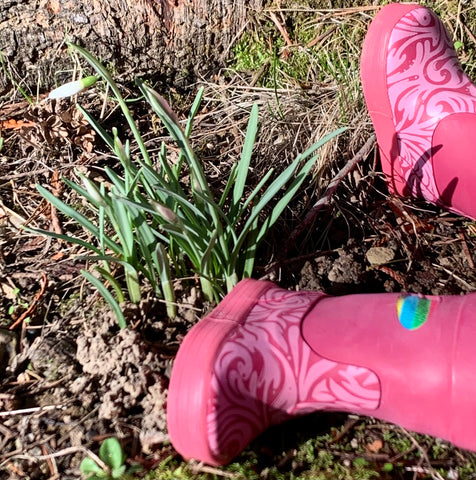 Tiny crocus buds in front of rain boots for 18-inch doll.