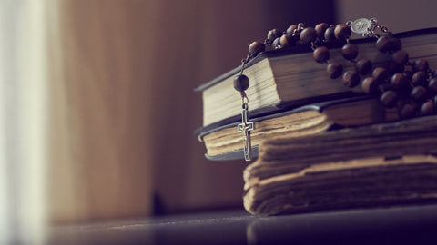 rosary on a stack of books