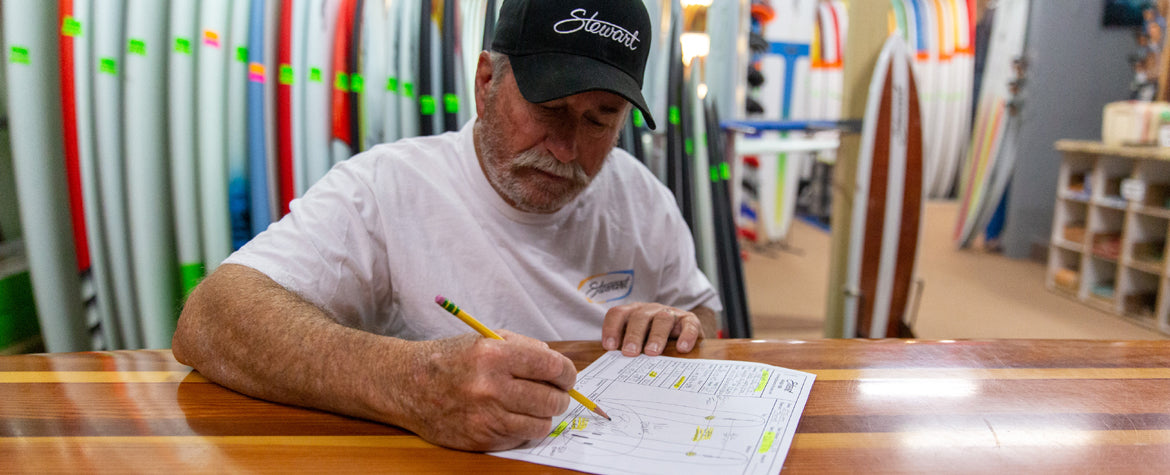 Bill Stewart writing up custom surfboard order