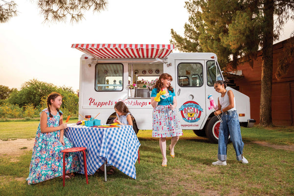 Stacey Gordon and 3 girls are having fun in front of her ice cream truck. 