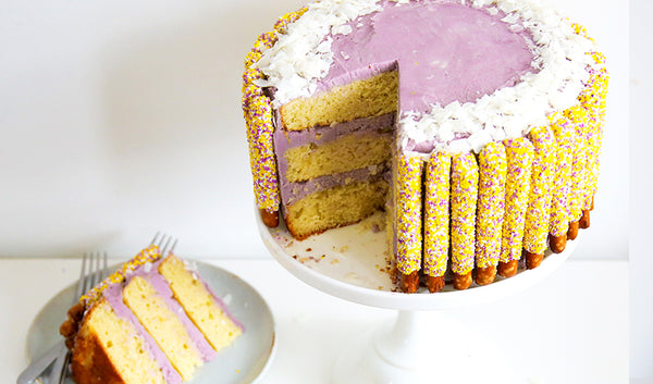 Yellow and purple cake decorated with Easter sprinkle chocolate pretzels