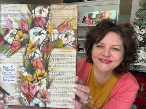 Pam holding a project made in the mixed media workshop