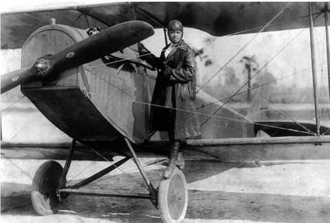 Bessie Coleman standing on the wing of her plane.