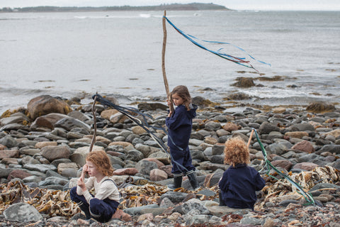 Children playing on beach in their Faire Child Weather Wear Sustainable Clothing.