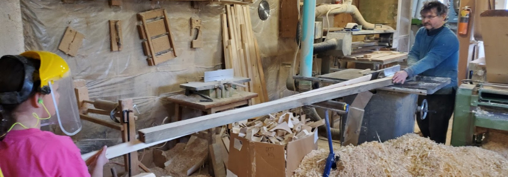 Father and daugther working on paddleboard project making wooden trips