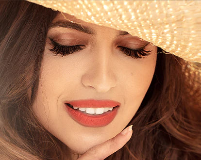 A woman has closed her eyes and shadow of hat is falling on her face