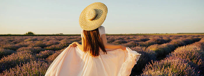 A girl with hat is standing on the farm & enjoying the view