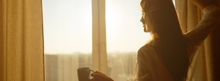 A girl is standing and holding a cup