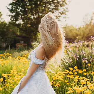 A woman in a gown is standing at the yellow flower farm