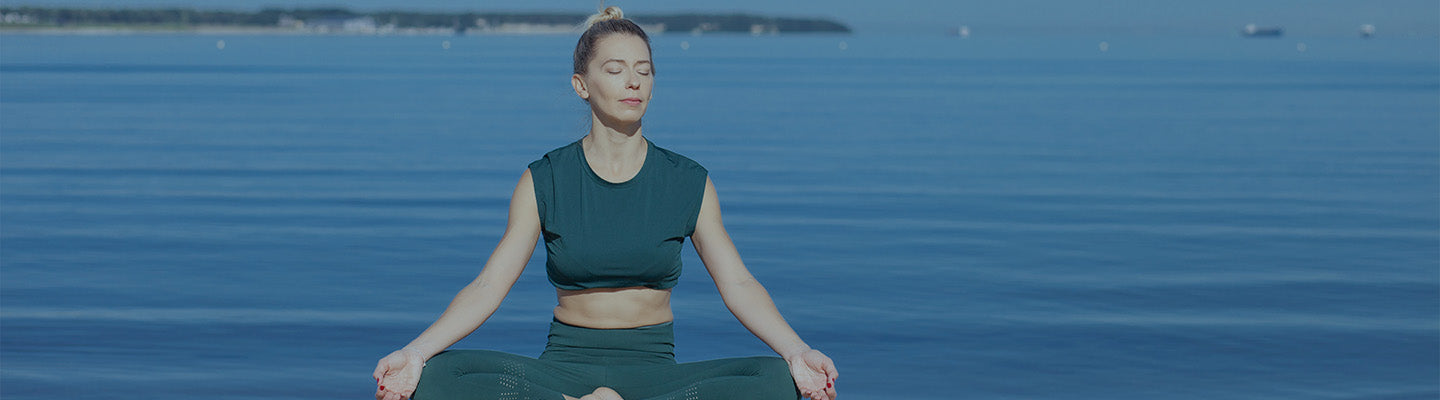 A woman is doing meditation on the beach