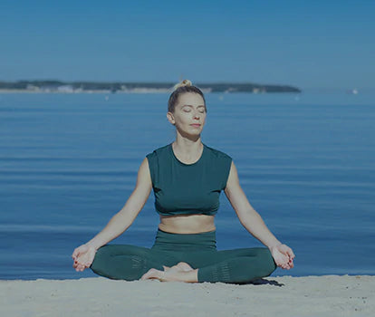 A woman is doing meditation on the beach
