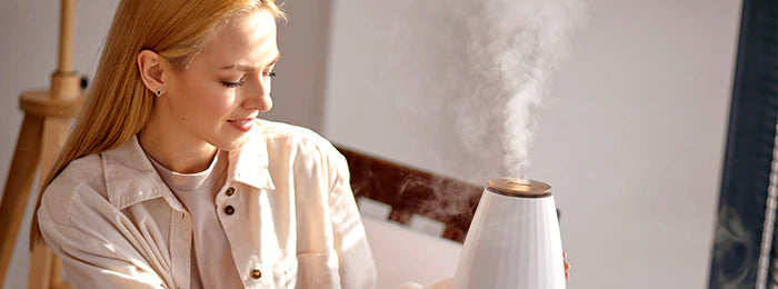 A woman is turning on the aroma diffuser 