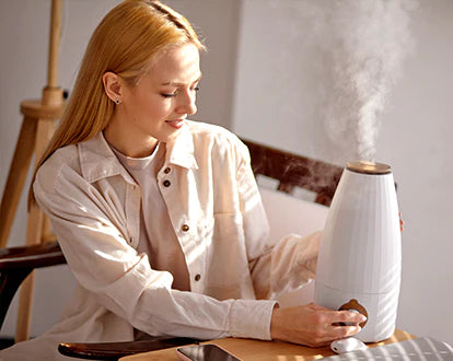 A woman is turning on the aroma diffuser 