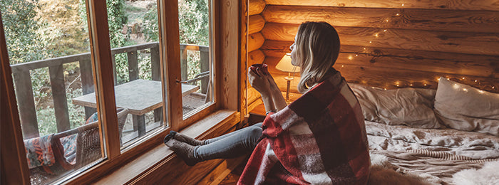 A girl is sitting on bed & holding a cup