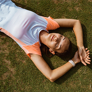 A girl is feeling relaxed by lying on the green field