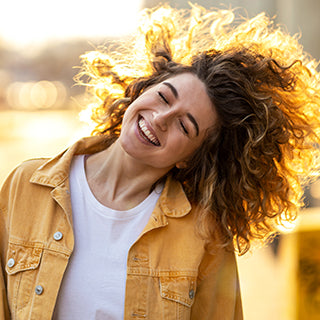 A curly hair girl is smiling