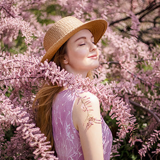 girl is standing beside purple plant