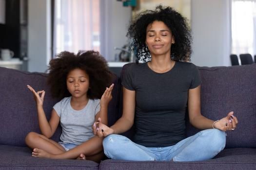 Mom and daughter sitting in yoga position