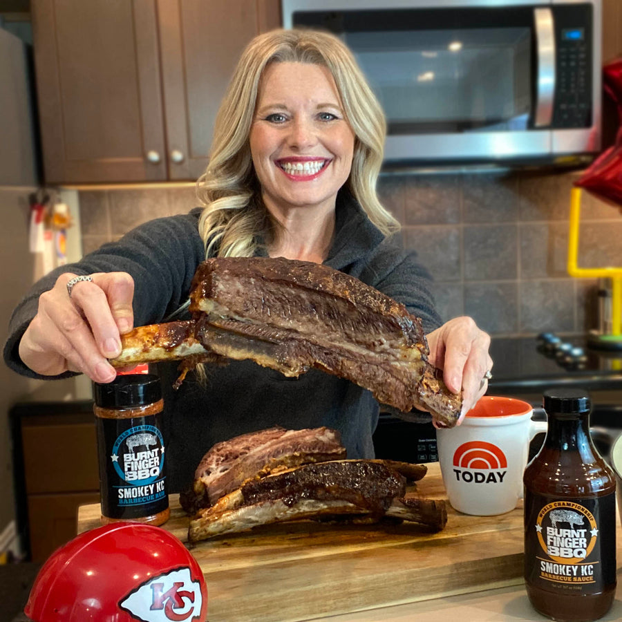 Pitmaster Megan Day holding smoked beef ribs