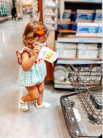 Baby girl playing with biodynamic baby food packet