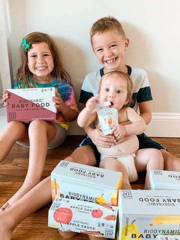 Kids sitting with baby food packets